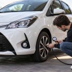 Un homme fait la pression des pneus sur une Toyota Yaris.